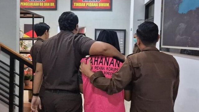 Luluk Hariadi saat digiring petugas Kejaksaan Negeri Bondowoso menuju mobil tahanan setelah resmi ditetapkan sebagai tersangka kasus dugaan korupsi dana hibah seragam tahun 2024, Senin (26/1/2026).