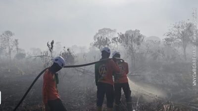 Personel Dit Samapta Polda Kalbar saat melakukan pendinginan dan penyemprotan air di lokasi kebakaran lahan di Desa Punggur Kecil, Kabupaten Kubu Raya, Minggu (18/1).