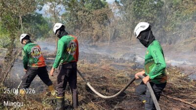 Personel gabungan saat melakukan proses pendinginan dan pembasahan lahan gambut yang masih mengeluarkan asap di Desa Punggur Kecil, Minggu (25/1).