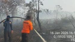 Personel gabungan yang tergabung dalam Tim Siaga Kebakaran Hutan dan Lahan saat melakukan proses pendinginan di area lahan gambut yang terbakar di Kubu Raya, Sabtu (17/1).