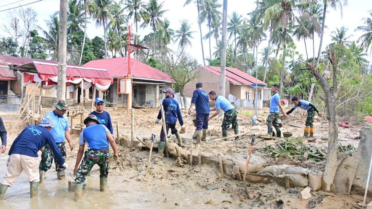 Sejumlah prajurit TNI AU berseragam kaos biru dan celana loreng bersama warga sipil sedang bergotong royong menyekop lumpur cair yang menggenangi jalanan permukiman pascabanjir. (Dok. HO/Faktakalbar.id)