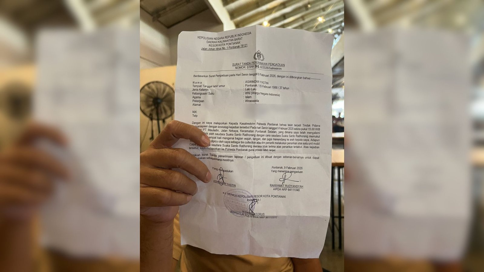 Aswindar Yastin saat memperlihatkan bukti laporan kepolisian terkait insiden dugaan penganiayaan yang dialaminya di Mapolresta Pontianak, Senin (9/2/2026). (Dok. Reni/Faktakalbar.id)
