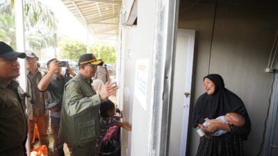 Kepala Badan Nasional Penanggulangan Bencana (BNPB) Letjen TNI Suharyanto, (kemeja hijau dan rompi hijau) saat menyapa dan menyerahkan bantuan bahan kebutuhan pokok kepada warga yang tinggal di hunian sementara (huntara) Pulo Tiga, Kabupaten Aceh Tamiang, Provinsi Aceh, pada Rabu (25/2) siang. (Dok. HO/Faktakalbar.id)