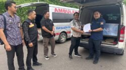 Petugas KJRI Kuching dan BP2MI saat mengawal ambulans yang membawa peti jenazah dua Pekerja Migran Indonesia asal NTB melewati gerbang PLBN Entikong, Kalimantan Barat, Jumat (13/2/2026).