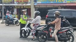 Petugas kepolisian dari Polres Kubu Raya saat memberikan masker kepada pengendara motor di tengah kabut asap guna mengantisipasi dampak buruk penurunan kualitas udara, Selasa (17/2/2026).