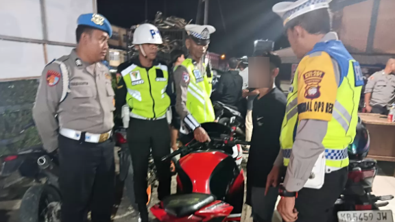 Petugas kepolisian dari Polres Melawi saat menghentikan dan memeriksa pengendara sepeda motor yang kedapatan menggunakan knalpot tidak sesuai standar (brong) dalam giat Operasi Keselamatan Kapuas 2026 di Jalan Juang, Sabtu (8/2).