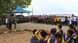 "Tumpukan sampah plastik di Pantai Pecal dibersihkan ratusan pelajar dan aparat gabungan. Respons program ASRI, soroti keberlanjutan kebersihan wisata."