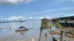 Personel TNI AL bersama warga membersihkan sampah di area perairan sungai menggunakan perahu kecil dalam rangka Program ASRI. (Dok. HO/Faktakalbar.id)