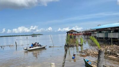 Personel TNI AL bersama warga membersihkan sampah di area perairan sungai menggunakan perahu kecil dalam rangka Program ASRI. (Dok. HO/Faktakalbar.id)