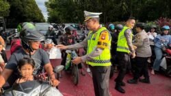 Personel Polwan Polda Kalbar saat membagikan paket takjil kepada pengendara motor yang melintas di kawasan Tugu Digulis Pontianak menjelang waktu berbuka.