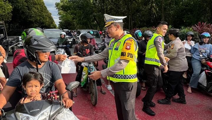 Personel Polwan Polda Kalbar saat membagikan paket takjil kepada pengendara motor yang melintas di kawasan Tugu Digulis Pontianak menjelang waktu berbuka.