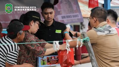 Wali Kota Singkawang Tjhai Chui Mie menyerahkan paket bantuan Imlek kepada warga dalam kegiatan bakti sosial Berbagi Kasih. (Dok. HO/Faktakalbar.id)
