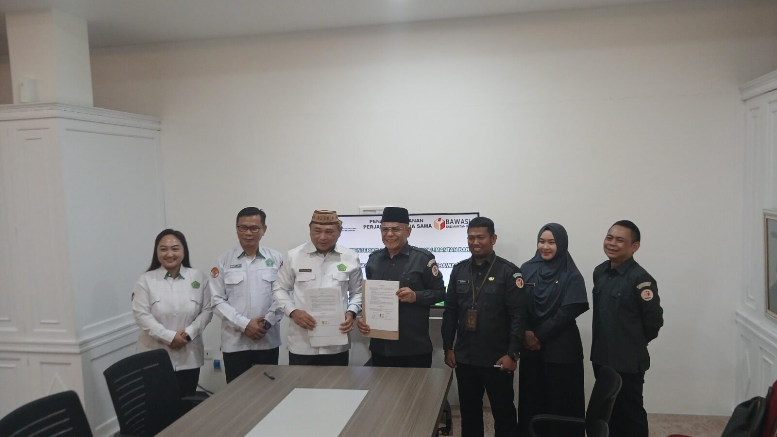 Ketua Bawaslu Kalbar Mursyid Hidayat dan Kakanwil Kemenag Kalbar Muhajirin Yanis menunjukkan dokumen MoU yang telah ditandatangani. (Dok. HO/Faktakalbar.id)