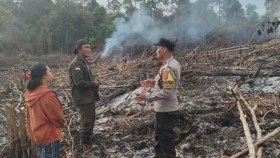 Bhabinkamtibmas Polsek Tayan Hilir saat melakukan verifikasi koordinat titik panas di lahan pertanian warga untuk memastikan tidak adanya potensi api yang meluas.