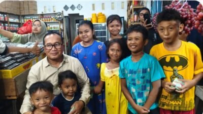 Bupati Kubu Raya, Sujiwo, tersenyum ceria saat berfoto bersama anak-anak dan warga setempat di sela-sela peninjauan penataan kawasan Pasar Kuala Dua yang dilakukan secara humanis. (Dok. HO/Faktakalbar.id)