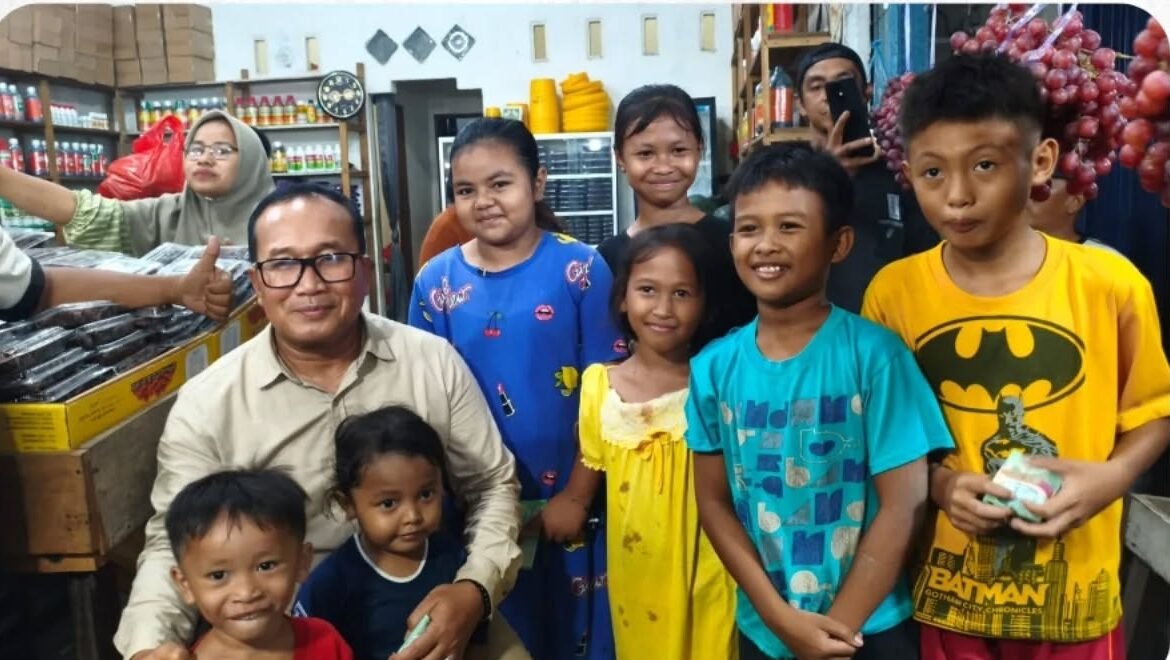Bupati Kubu Raya, Sujiwo, tersenyum ceria saat berfoto bersama anak-anak dan warga setempat di sela-sela peninjauan penataan kawasan Pasar Kuala Dua yang dilakukan secara humanis. (Dok. HO/Faktakalbar.id)