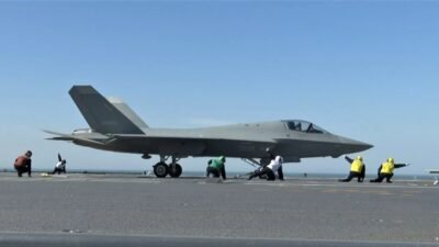 Jet tempur siluman J-35 Angkatan Laut China sedang bersiap lepas landas dengan panduan kru dek di atas kapal induk Fujian. (Dok. Ist)