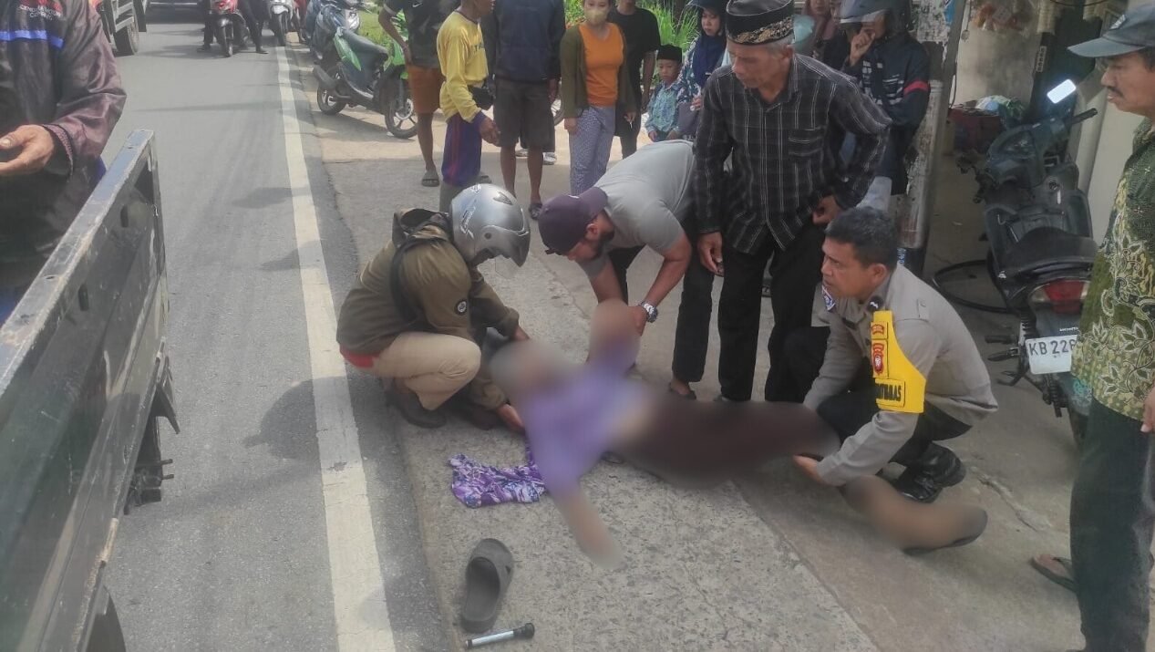 Petugas dibantu warga sekitar mengevakuasi korban kecelakaan maut yang melibatkan sepeda motor dan truk di Jalan Sultan Agung, Kecamatan Rasau Jaya, Kabupaten Kubu Raya, Kamis (26/2/2026).