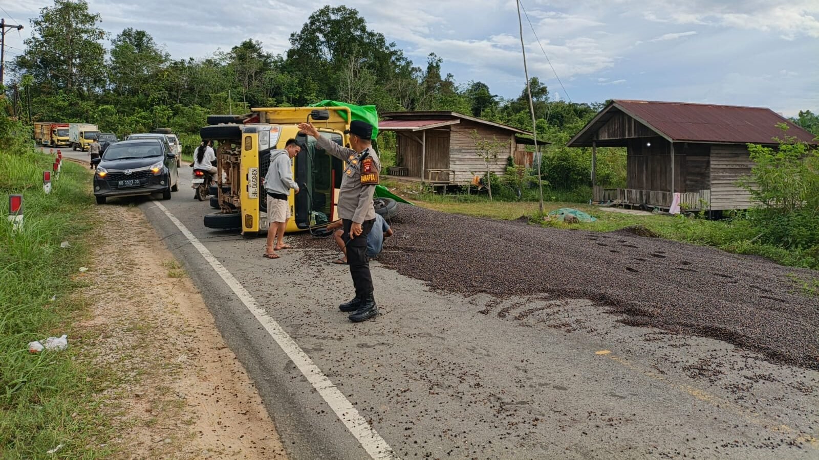 Kondisi truk bermuatan biji kelapa sawit yang tumbang dan menutupi badan jalan di tikungan Desa Tanjung Tengang, Kabupaten Melawi.