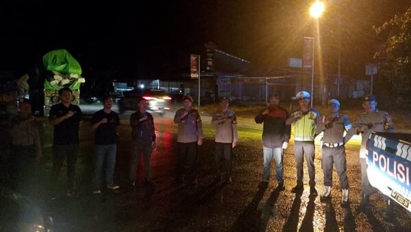 Personel Polres Sekadau saat memberikan imbauan kepada sopir truk di pinggir jalan utama guna memastikan kelancaran lalu lintas dan mencegah balap liar, Sabtu (14/2/2026) malam.