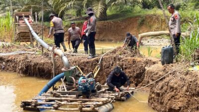 Personel Polsek Sekayam saat melakukan pemusnahan mesin dompeng di lokasi pertambangan emas tanpa izin di pinggir Sungai Kayan, Kamis (5/2/2026).