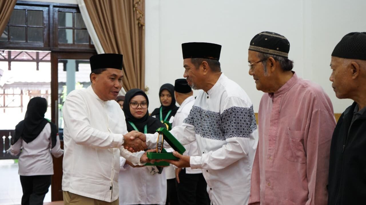 Asisten Pemerintahan dan Kesejahteraan Rakyat Sekretariat Daerah Kota Pontianak Ismail menyerahkan cenderamata kepada perwakilan peserta dalam pembukaan Rakorda IX UPZ Masjid dan Surau se-Kota Pontianak. (Dok. HO/Faktakalbar.id)