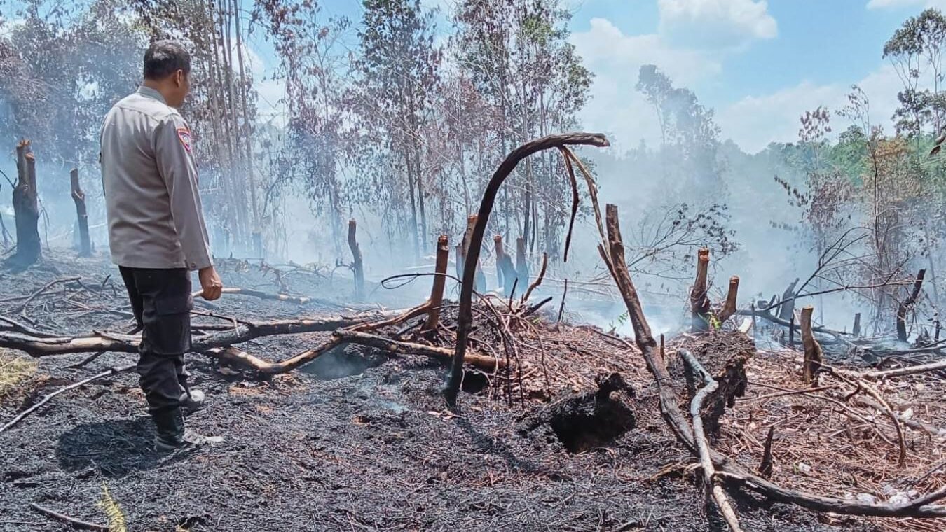 Personel Polsek Kapuas saat melakukan pengecekan lapangan (ground check) di lokasi lahan warga yang terdeteksi sebagai titik panas, Senin (9/2/2026).