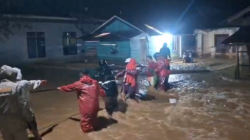 Petugas BPBD Kabupaten Agam saat mengevakuasi warga terdampak banjir menuju tempat pengungsian sementara di wilayah Kecamatan Tanjung Raya, Rabu (11/1/2026).