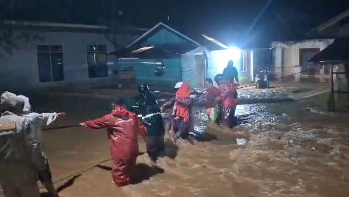 Petugas BPBD Kabupaten Agam saat mengevakuasi warga terdampak banjir menuju tempat pengungsian sementara di wilayah Kecamatan Tanjung Raya, Rabu (11/1/2026).