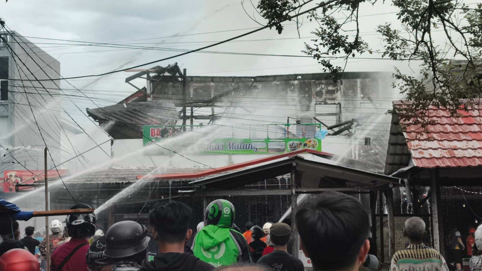 Sejumlah personel pemadam kebakaran saat melakukan upaya pendinginan pada bagian atap ruko yang terbakar di Jalan Purnama I, Kota Pontianak, Selasa (17/2/2026).