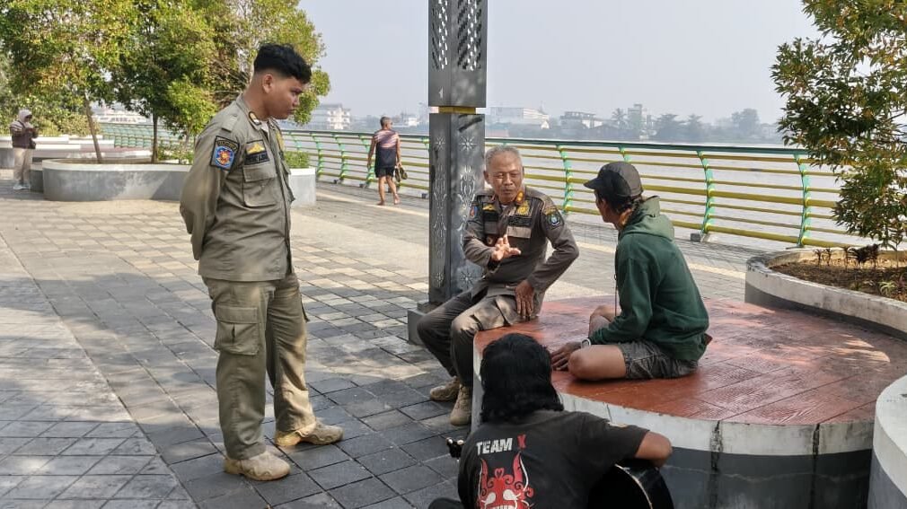 Personel Satpol PP Kota Pontianak saat memberikan teguran persuasif dan imbauan kepada warga di kawasan Waterfront City guna menjaga ketertiban lingkungan.