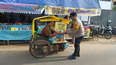 Anggota kepolisian membagikan takjil gratis kepada seorang bapak pendorong becak di pinggir jalan pada bulan suci Ramadan. (Dok. HO/Faktakalbar.id)