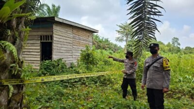 Personel kepolisian memasang garis polisi di lokasi penemuan mayat pada sebuah pondok kebun terbengkalai di Desa Air Upas. (Dok. HO/Faktakalbar.id)