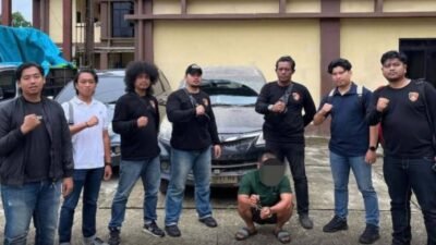 Terduga pelaku penggelapan mobil berinisial RS saat dikawal petugas menuju Mapolres Kapuas Hulu bersama barang bukti satu unit Toyota Avanza hitam, Jumat (13/2/2026).