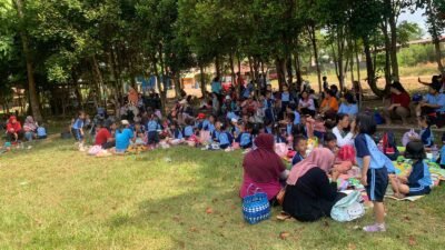 Peserta didik TK Tunas Harapan bersama guru dan orang tua duduk lesehan saat kegiatan rekreasi edukatif di Taman Kota Marau. (Dok. HO/Faktakalbar.id)