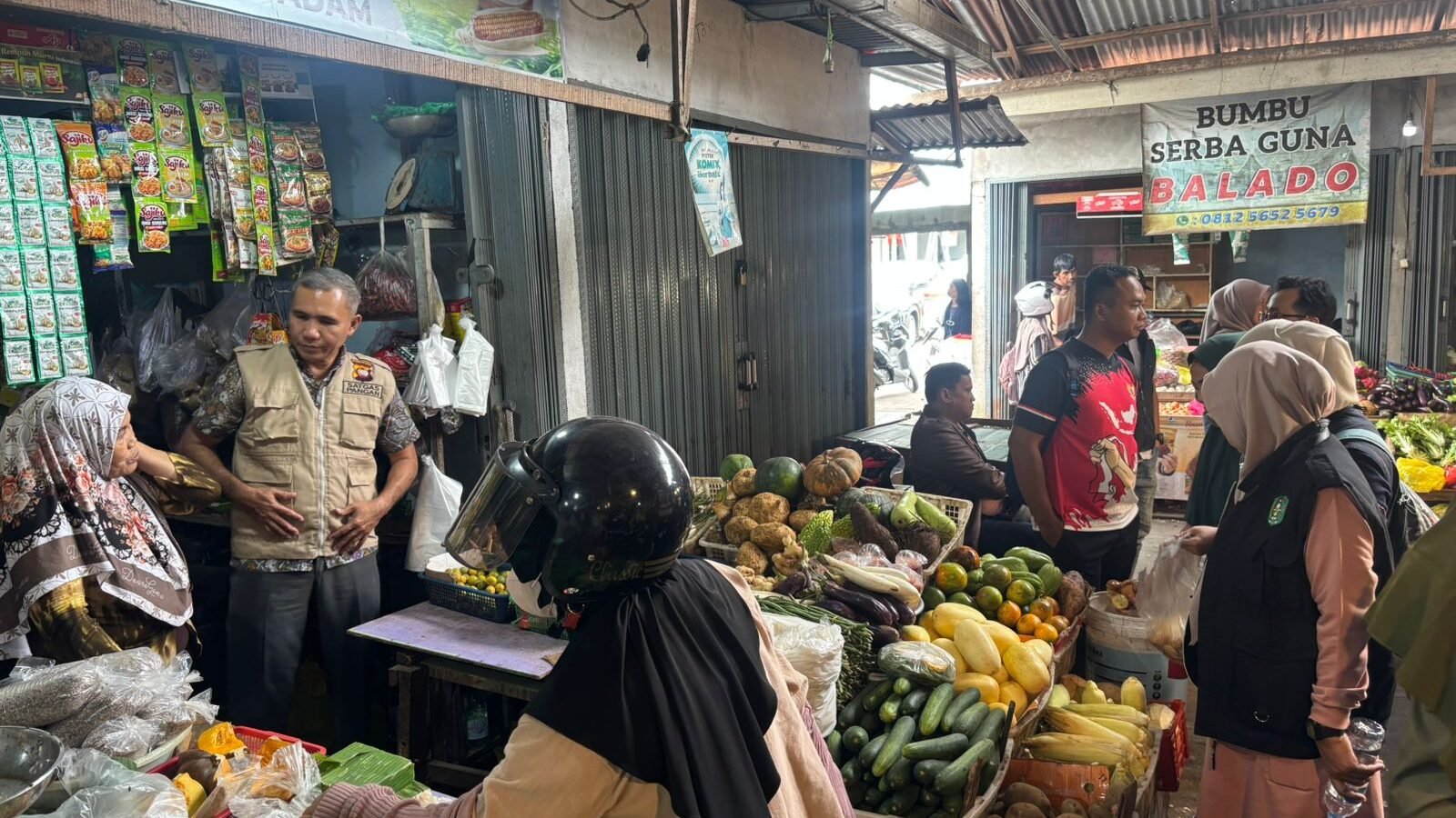 Anggota Satgas Pangan Polda Kalbar berdialog dengan pedagang sayur saat memantau harga bahan pokok di Pasar Swadaya Sungai Raya Dalam. (Dok. HO/Faktakalbar.id)