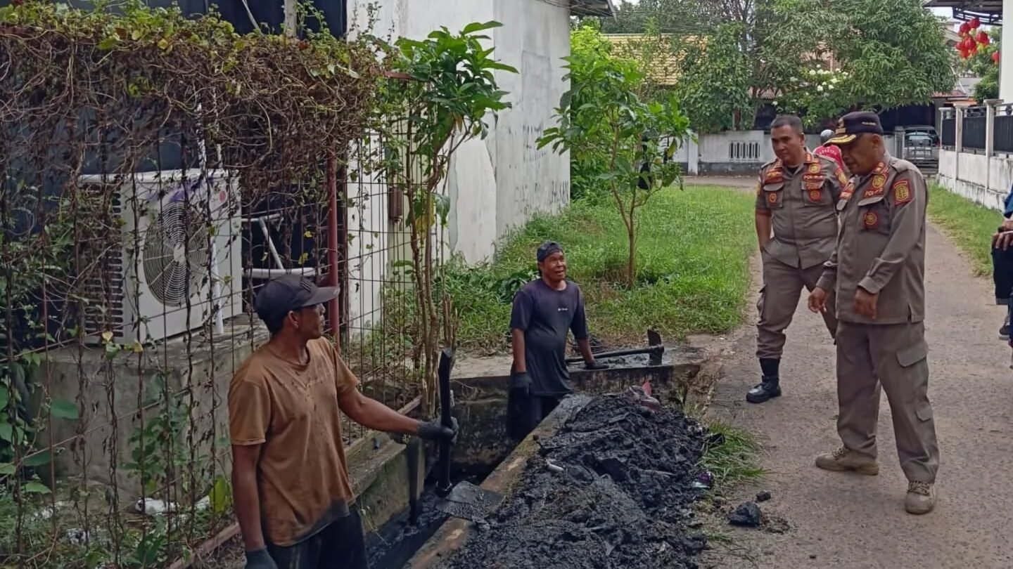 Petugas Satpol PP Kabupaten Ketapang sedang memantau pekerja yang melakukan pengerukan lumpur dalam proyek rehabilitasi saluran drainase di Jalan Basuki Rahmat. (Dok. HO/Faktakalbar.id)