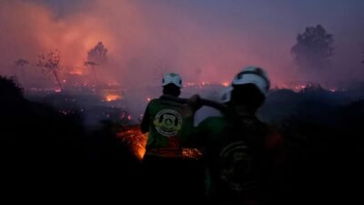 Personel Tim SAR Dit Samapta Polda Kalbar saat melakukan proses pendinginan lahan (cooling down) di kawasan Parit Toom, Kecamatan Rasau Jaya, untuk mencegah api kembali menyala, Selasa (3/2/2026).