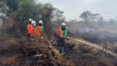 Personel gabungan TNI-Polri dan BNPB saat melakukan pembasahan lahan gambut yang masih mengeluarkan asap di Parit Toom, Desa Punggur Besar, Kubu Raya.
