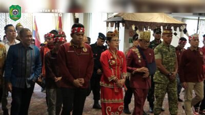 Wali Kota Singkawang Tjhai Chui Mie dan Wakil Wali Kota Muhammadin mengenakan pakaian adat saat memasuki ruangan pelantikan Pengurus Pemuda Dayak Kota Singkawang di Mahkota Hotel. (Dok. HO/Faktakalbar.id)