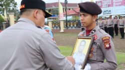 Kapolres Kapuas Hulu Roberto Aprianto Uda saat melakukan pencoretan foto personel dalam upacara Pemberhentian Tidak Dengan Hormat (PTDH) di lapangan Mapolres, Kamis (12/2/2026).