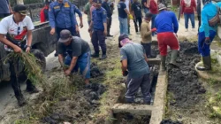 Warga Kelurahan Kapuas Kanan Hilir bersama petugas gabungan saat membersihkan saluran air yang tersumbat sampah dan lumpur, Sabtu (7/2).