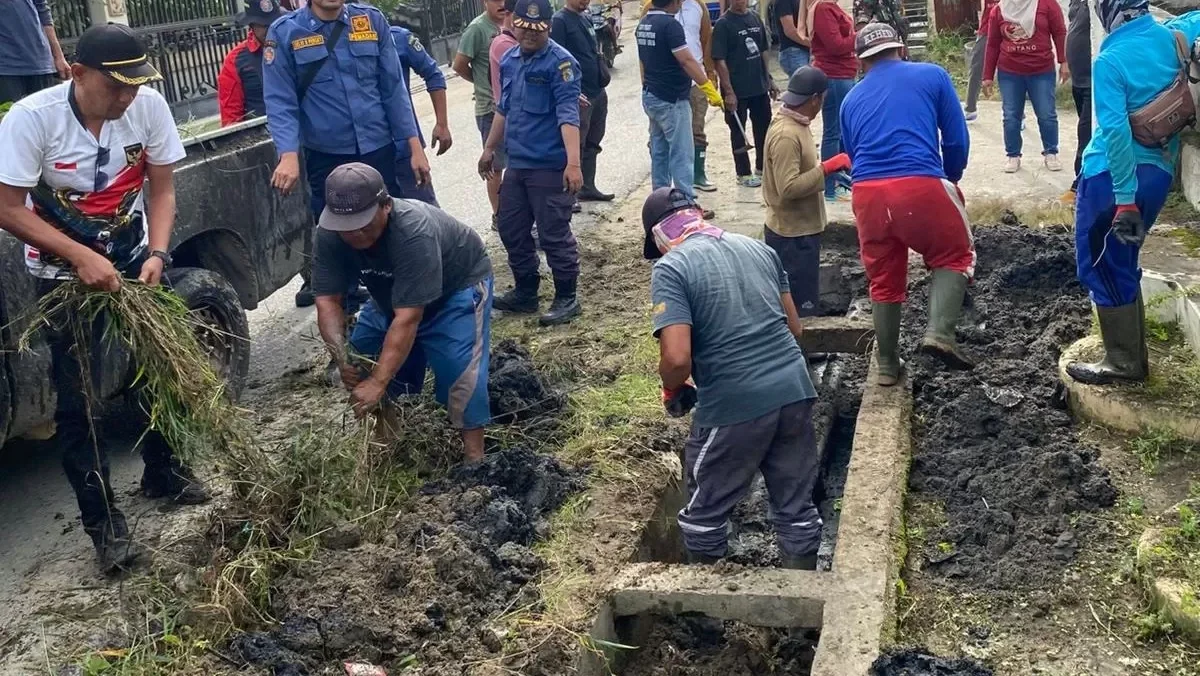 Warga Kelurahan Kapuas Kanan Hilir bersama petugas gabungan saat membersihkan saluran air yang tersumbat sampah dan lumpur, Sabtu (7/2).