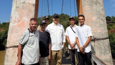 Bupati Ketapang Alexander Wilyo berfoto bersama warga di depan jembatan gantung Dusun Tanjung Lambai saat kunjungan kerja infrastruktur listrik. (Dok. HO/Faktakalbar.id)