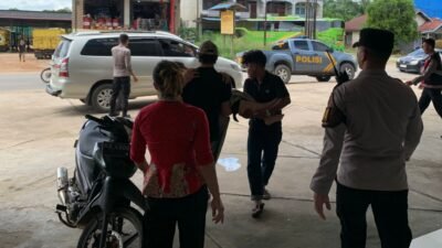Personel kepolisian bersama warga sekitar saat mengevakuasi korban kecelakaan lalu lintas yang melibatkan dua unit sepeda motor di Jalan Raya Desa Sidomulyo, Kabupaten Melawi.