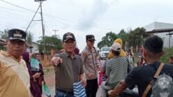 Sekretaris Kecamatan Marau Esau Londong dan personel Polsek Marau membagikan takjil gratis kepada pengendara motor. (Dok. HO/Faktakalbar.id)