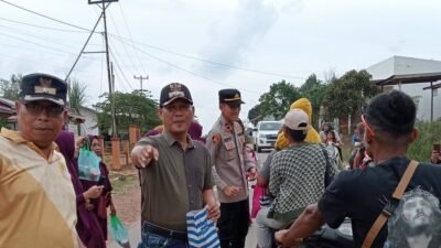 Sekretaris Kecamatan Marau Esau Londong dan personel Polsek Marau membagikan takjil gratis kepada pengendara motor. (Dok. HO/Faktakalbar.id)