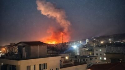 Pemandangan malam hari sebuah kota dengan gumpalan asap tebal dan api membumbung tinggi akibat ledakan di tengah pemukiman. (Dok. Ist)