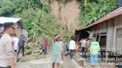 petugas BPBD saat melakukan penanganan darurat dan pembersihan material tanah longsor yang menimpa bangunan rumah warga di permukiman rawan bencana.