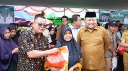 Bupati Melawi Dadi Sunarya Usfa Yursa mendampingi perwakilan Bank Kalbar saat menyerahkan paket sembako murah kepada warga di lokasi Operasi Pasar. (Dok. HO/Faktakalbar.id)